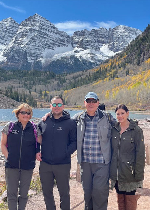 The image shows a family picture of Dr. Briskie. The background is a mountain and a river. | Revive Dental implants and dentistry in Longmont, CO