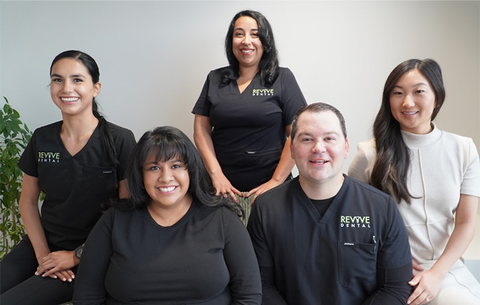 Revive-Dental team group photo with a plain white background and plants on the left side.